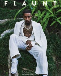 a man sitting on top of a lush green field