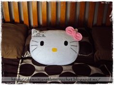 a crocheted hello kitty pillow on top of a bed