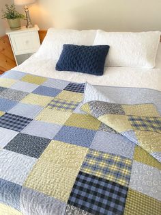 a bed with a blue and yellow quilt on it