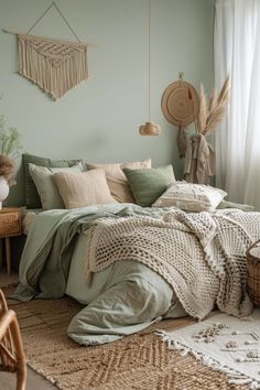 a bed with green sheets and pillows in a room next to a wicker basket