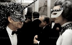 two people dressed up in masks and tuxedos