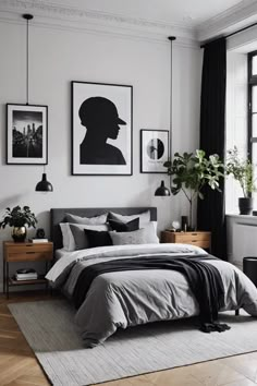 a bedroom with white walls, black and grey bedding and pictures on the wall