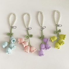 four crocheted key chains with bows and pearls hanging from each one's side