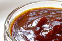 a glass jar filled with sauce sitting on top of a table