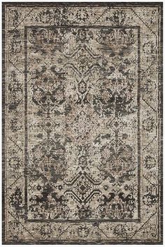 an area rug with black and white designs on the front, in greys and browns