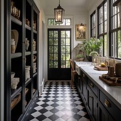 a black and white checkered floor in a kitchen with lots of cupboards on either side