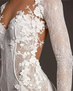 the back of a wedding dress with white flowers on it