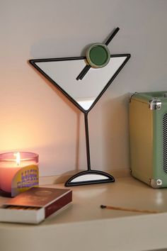 a table with a lit candle and a book on it next to a small radio