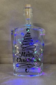 a glass bottle with a christmas tree on it