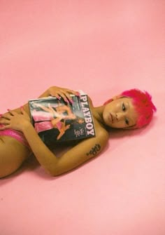 a doll with pink hair laying on the ground