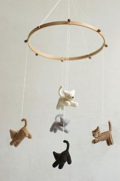 a crocheted mobile with cats and dogs hanging from it