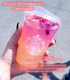 a person holding up a pink drink with ice and berries on it, in front of the words peach strawberry lemonade