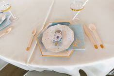 a white table topped with plates and silverware