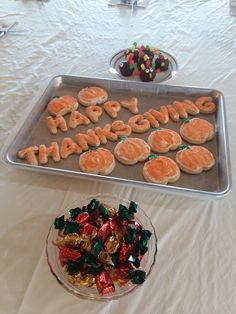 a tray with cookies and candies that say happy thanksgiving on it, along with a bowl of candy