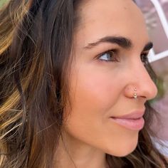 a close up of a woman with a nose piercing