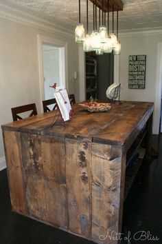 a kitchen island made out of an old wooden box and some lights hanging from the ceiling