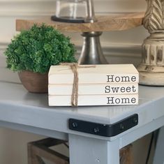 two books sitting on top of a table next to a potted plant