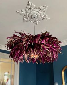 a chandelier hanging from the ceiling in a room with blue walls and white trim