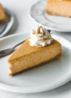 a slice of pumpkin pie on a plate with a fork next to the rest of the pie