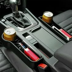 the interior of a car with two cup holders and other items in it's compartment