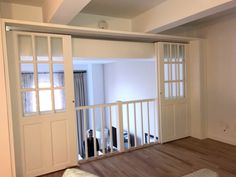 an empty living room with sliding doors and hard wood flooring on the hardwood floors