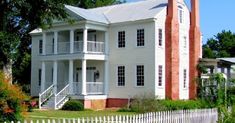 a large white house sitting on top of a lush green field