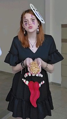 a woman in a black dress is holding a candy bag