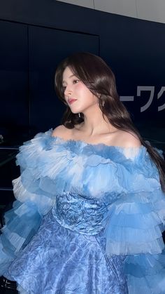 a woman in a blue dress posing for the camera