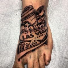 a man's foot with a tattoo on it that says las vegas and two stacks of money