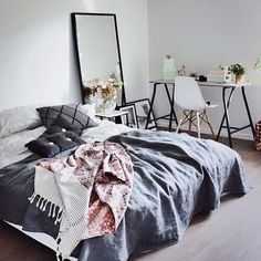 an instagramted photo of a bed in a room with white walls and wooden floors