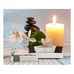 a lit candle sitting on top of a table next to a white couch and vase