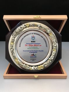 an award plaque is displayed in a wooden box