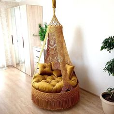 a hammock chair in the middle of a room with potted plants on the floor