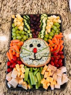 a tray filled with fruit, vegetables and cheese