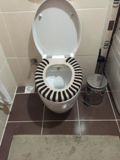 a white toilet sitting in a bathroom next to a trash can