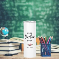 a white can with the words best teacher ever on it next to books and pencils