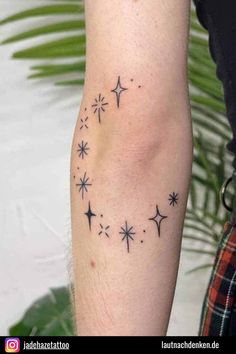 a person with a tattoo on their arm that has stars in the sky above them