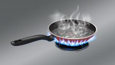 a frying pan filled with boiling water on top of a gas burner that has blue flames coming out of it