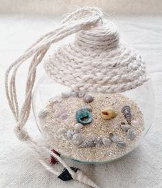 a glass bowl filled with sand and seashells