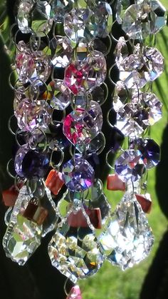 a wind chime hanging from a tree with lots of crystal beads on it's sides