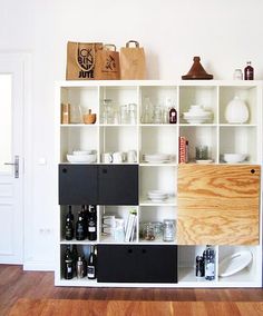 a white book shelf filled with lots of different types of bottles and containers on top of it