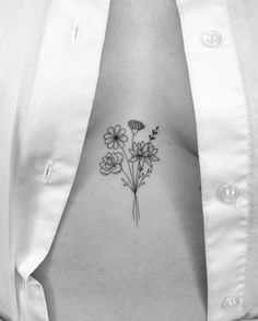 a black and white photo of a woman's stomach with flowers on it