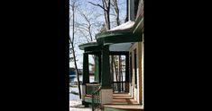 a porch with snow on the ground and trees in the background