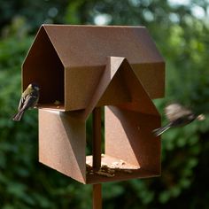 a bird that is sitting on top of a bird house with a bird in it