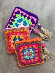 two crocheted bags with tassels on them