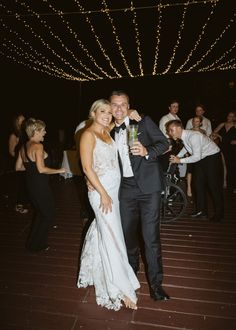 a man and woman standing next to each other on a dance floor with people in the background