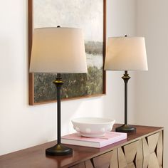 two lamps sitting on top of a table next to a bowl