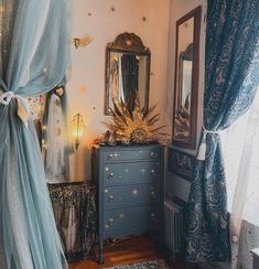 a bedroom with a dresser, mirror and curtains