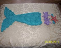 a crocheted mermaid tail and starfish on a bed