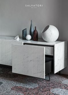 a marble sideboard with two vases on top